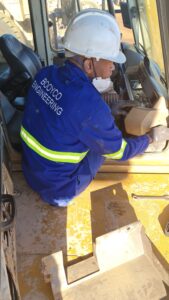 A Booyco Engineering field technician inspecting an HVAC installation on a mining vehicle.