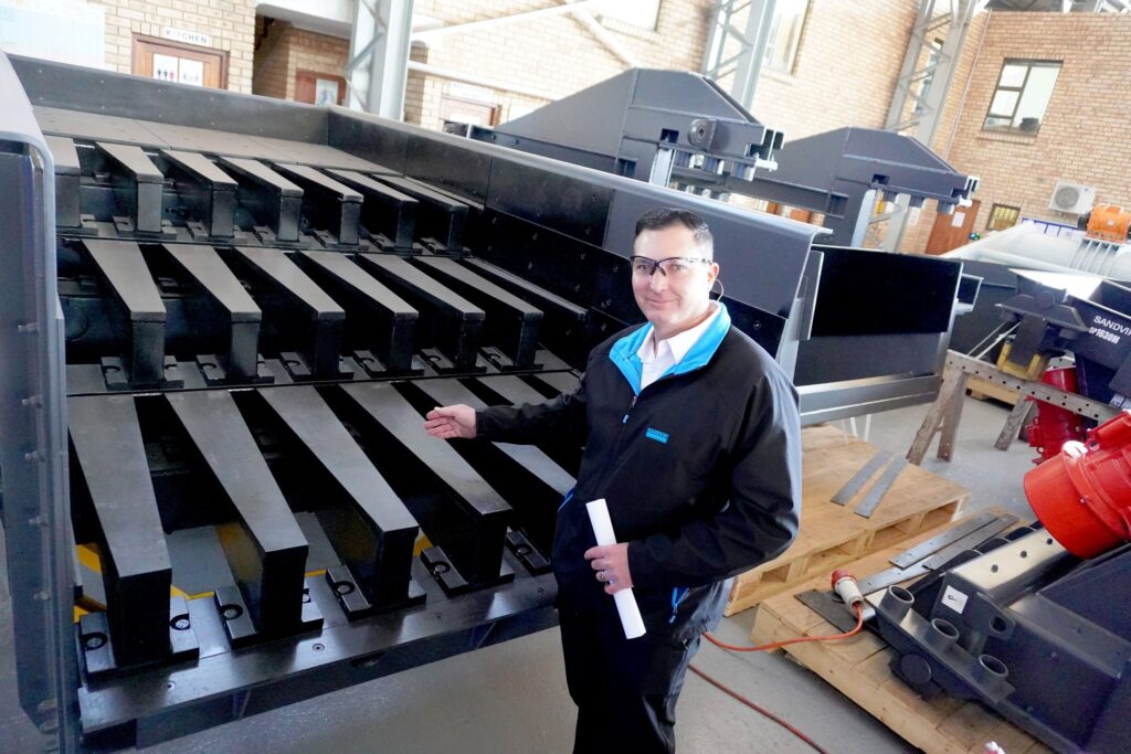 Riaan Steinmann, Europe, Middle East and Africa (EMEA) Operation Director Screening Solutions at Sandvik Rock Processing, showing the grizzly bars which were manufactured using VRN500 high manganese durable plates, equivalent to AR500 plates.