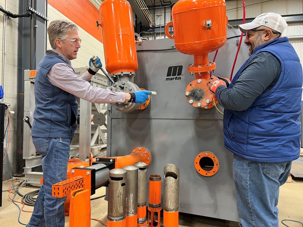 Martin Engineering business development manager Mike Masterson and product manager Sid Dev working at the Air Cannon test stand at the company’s industry-leading Centre for Innovation.