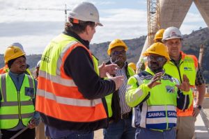 SANRAL CEO Reginald Demana (in SANRAL reflector jacket) receives a progress report from Laurence Savage, Msikaba Bridge Project Director.