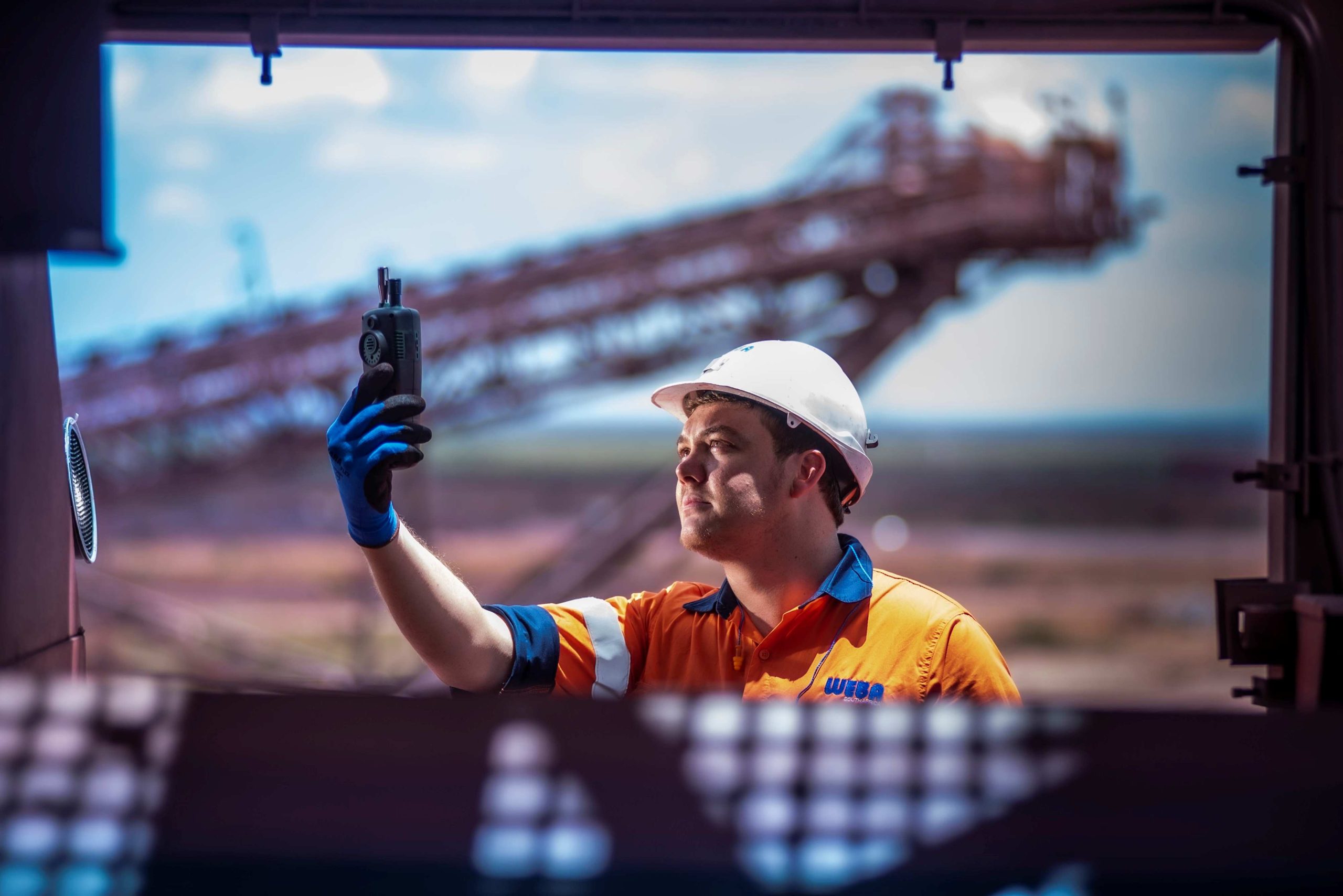 A Weba Chute Systems manager assessing dust at a transfer point. Dust control solutions improve safety and minimise environmental impact.