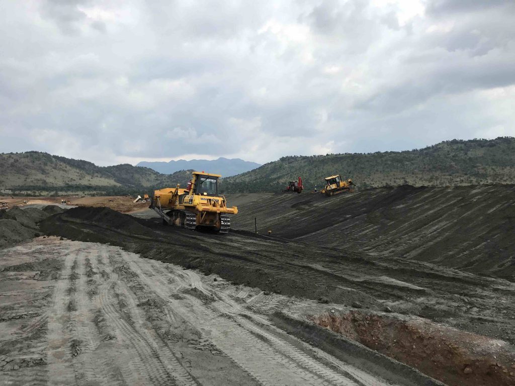 Filtered tailings being spread and prepared as bedding for barrier system.