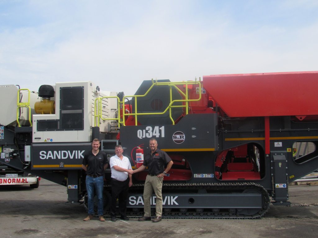 From left: PC Kruger, Business Line Manager Crushing at Sandvik Rock Processing, Jaco Benade, Distributor Manager at Sandvik Rock Processing and Stephen Smith, Managing Director of S&R Enterprises in front of the first Sandvik unit sold by the newly appointed distributor.